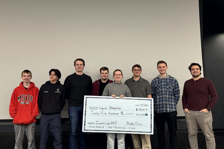 Team Liquid Boogaloo holds Brady's prize check after winning the Fall 2024 Innovation Lab.